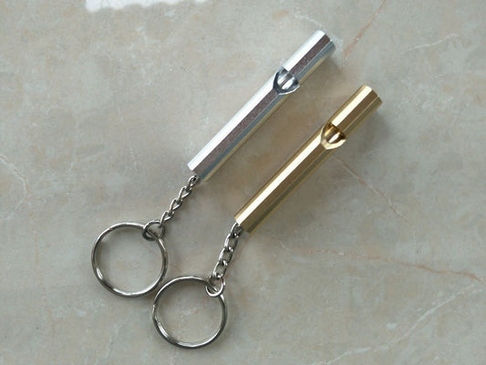 AlphaLife247 lightweight aluminum alloy survival whistle with keychain for outdoor emergency signaling and field communication.