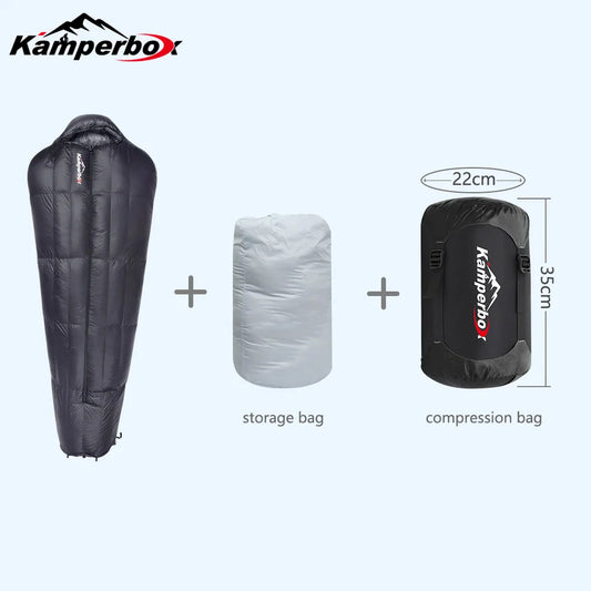 An AlphaLife247 Kamperbox ultralight winter sleeping bag in deep charcoal, displayed alongside its storage and compression bags to illustrate its compact, expedition-ready design.