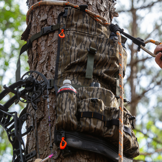 AlphaLife247 Tree Hugger modular hunting pack in BottomLand camo attached to a tree for quiet, organized gear access.