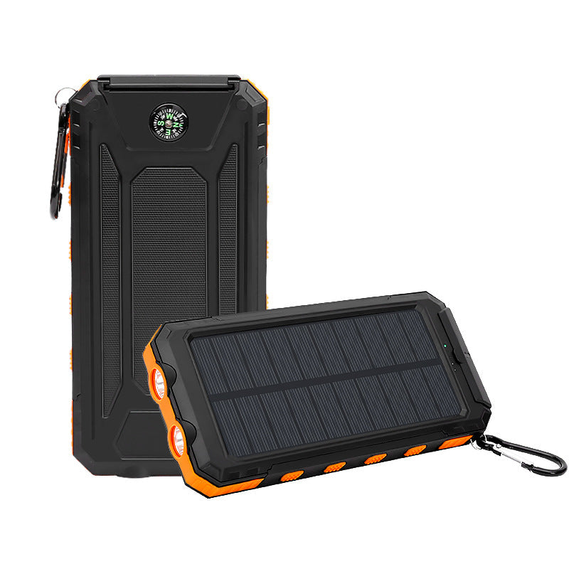 An AlphaLife247 rugged solar power bank shown from two angles — upright displaying the built-in compass and carabiner clip, and flat revealing the monocrystalline solar panel — in black and orange, with dual USB output, SOS flashlight, and 10000mAh capacity for off-grid emergency power.