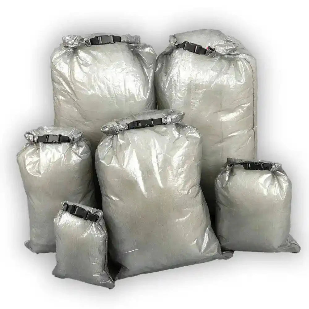 "An AlphaLife247 lightweight, gray roll-top dry bag made of Dyneema Composite Fabric, displayed in an outdoor setting to demonstrate its weather-resistant storage capabilities for hiking gear."