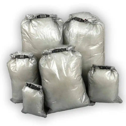 "An AlphaLife247 lightweight, gray roll-top dry bag made of Dyneema Composite Fabric, displayed in an outdoor setting to demonstrate its weather-resistant storage capabilities for hiking gear."